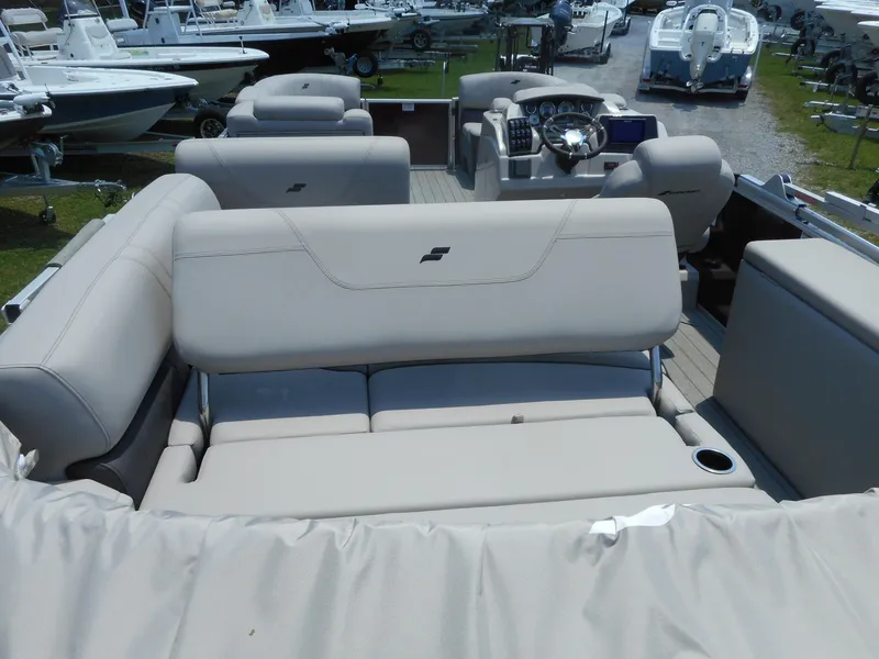 Slide: The Image of 2023 Starcraft CX 23 Q pontoon boat interior with beige seating and steering console. - 9