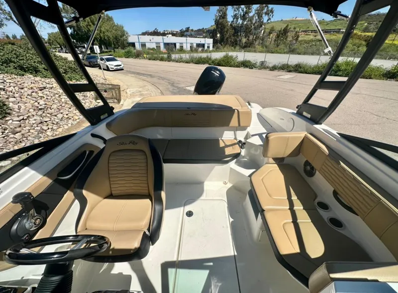 Slide: The Image of 2023 Sea Ray SPX 190 Outboard boat interior with tan seating and steering wheel. - 11