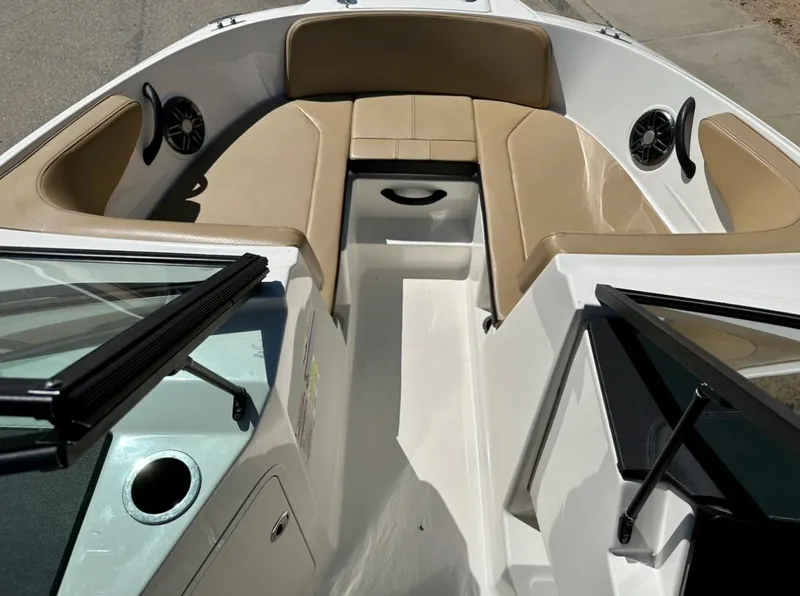 Slide: The Image of 2023 Sea Ray SPX 190 Outboard boat interior with tan seating and speakers. - 12
