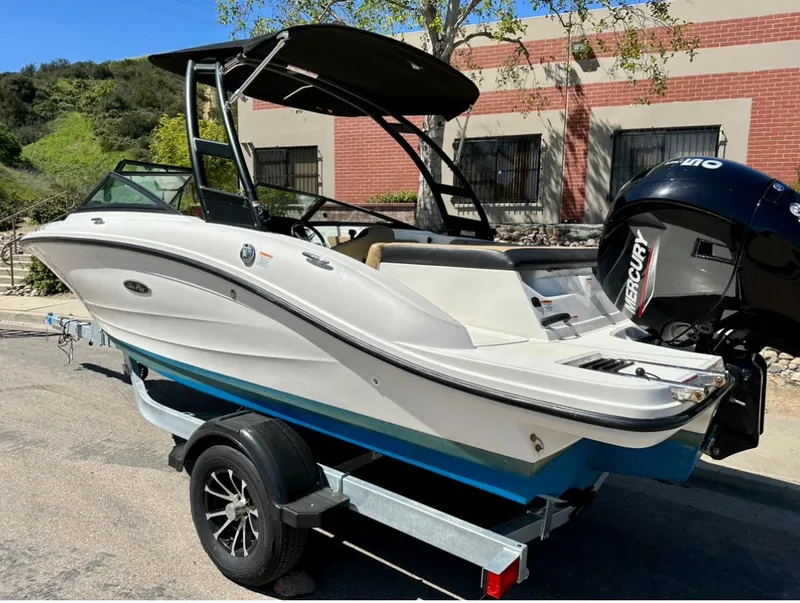Slide: The Image of 2023 Sea Ray SPX 190 Outboard boat on trailer, parked outdoors. - 2