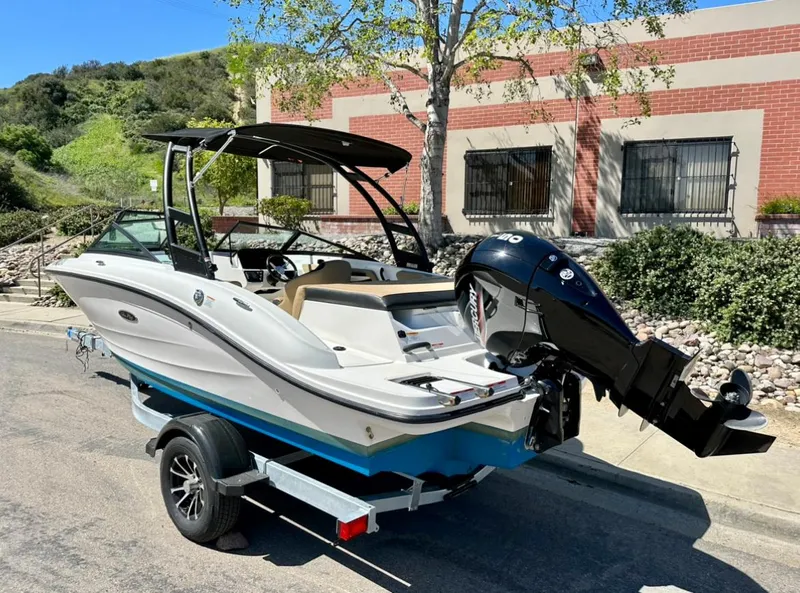 Slide: The Image of 2023 Sea Ray SPX 190 Outboard boat on trailer, parked outdoors near building. - 3