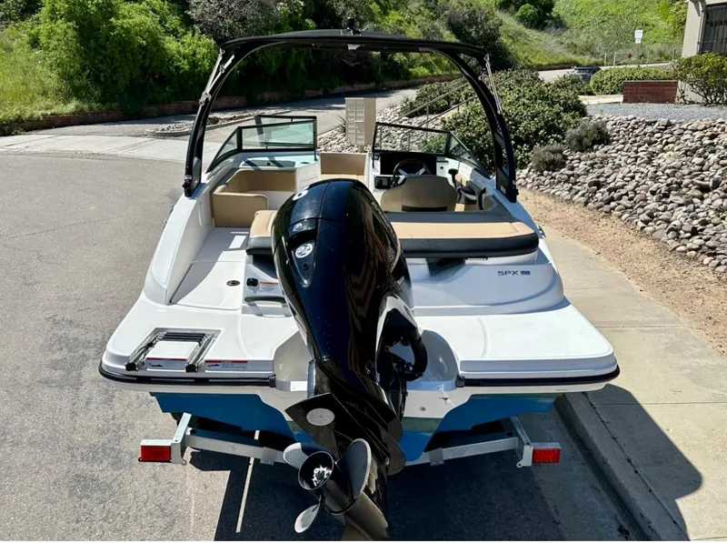 Slide: The Image of 2023 Sea Ray SPX 190 Outboard boat on trailer, parked on a sunny street. - 5