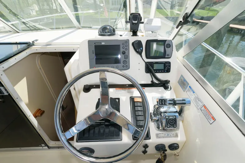 Slide: The Image of 2006 Pursuit 3070 Offshore boat helm with steering wheel, navigation equipment, and controls. - 10