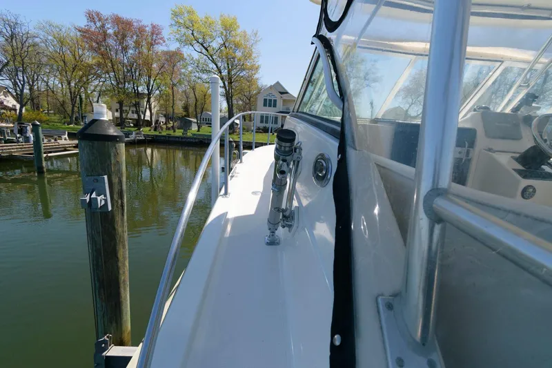 Slide: The Image of 2006 Pursuit 3070 Offshore boat docked near waterfront homes. - 13