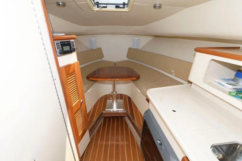Slide: The Image of 2006 Pursuit 3070 Offshore cabin interior with wooden flooring and compact kitchen. - 14