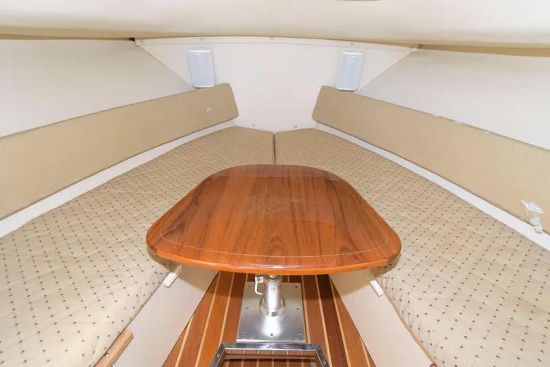 Slide: The Image of 2006 Pursuit 3070 Offshore cabin interior with wooden table and cushioned seating. - 15