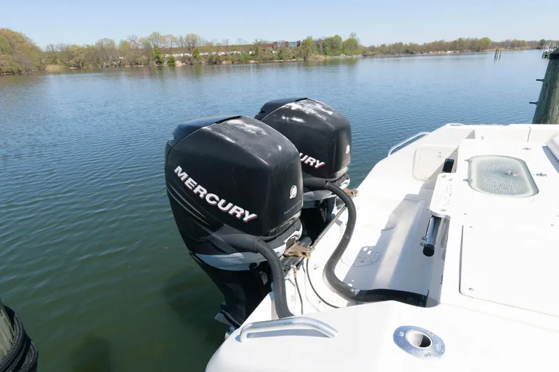 Slide: The Image of 2006 Pursuit 3070 Offshore boat with twin Mercury outboard engines on a calm lake. - 19