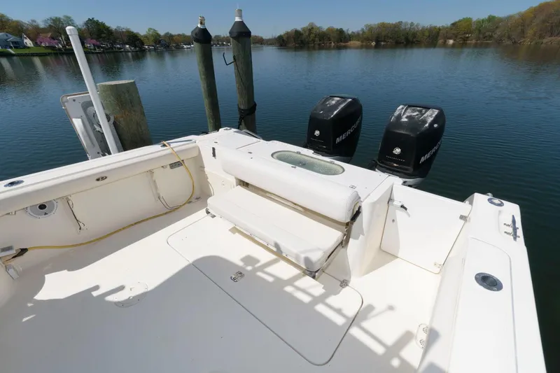 Slide: The Image of 2006 Pursuit 3070 Offshore boat with twin Mercury outboard engines docked on a calm lake. - 5