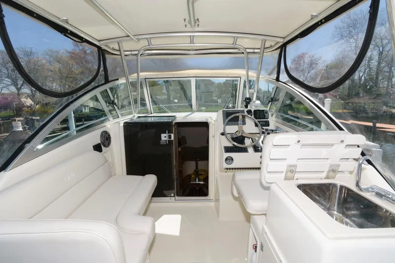Slide: The Image of 2006 Pursuit 3070 Offshore boat interior with helm, seating, and sink. - 6