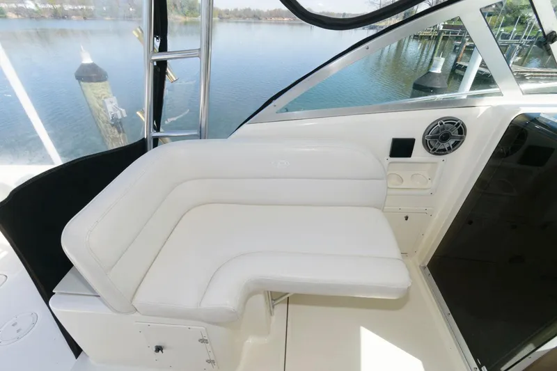 Slide: The Image of 2006 Pursuit 3070 Offshore boat interior with white seating and water view. - 7