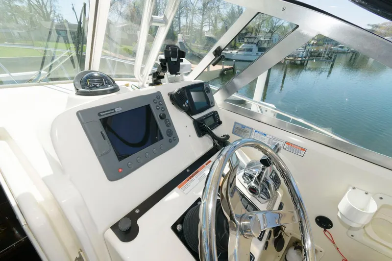 Slide: The Image of 2006 Pursuit 3070 Offshore boat helm with navigation equipment and steering wheel. - 9