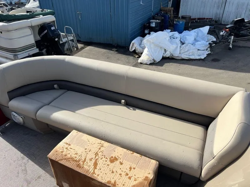 Slide: The Image of 2023 Sun Tracker PARTY BARGE® 18 DLX pontoon boat seating area in a marina. - 3