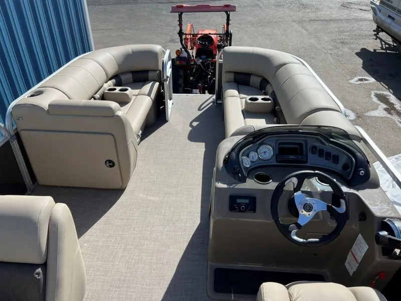 Slide: The Image of 2023 Sun Tracker PARTY BARGE® 20 DLX interior with beige seating and steering console. - 6