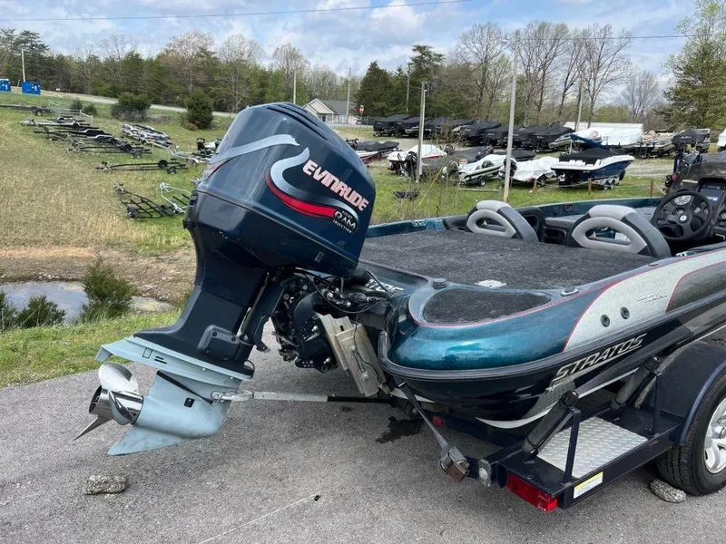 Slide: The Image of 2000 Stratos 20ss boat with Evinrude outboard motor in a parking lot. - 8