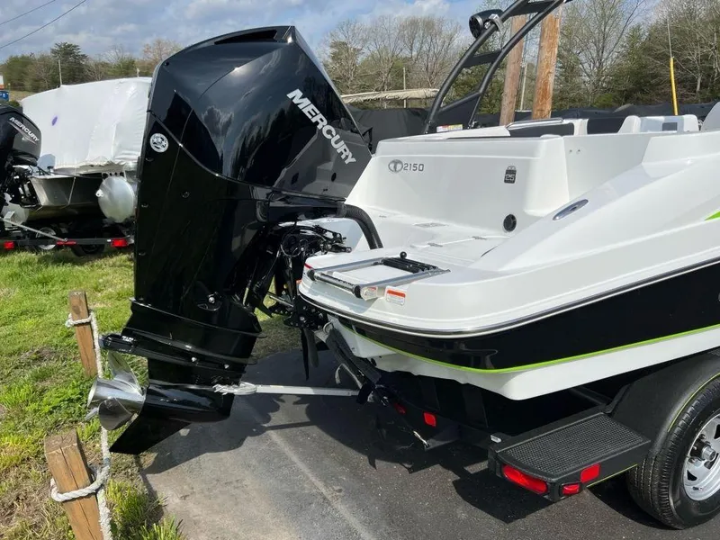 Slide: The Image of 2023 Tahoe 2150 boat with Mercury outboard motor, parked on a trailer. - 2