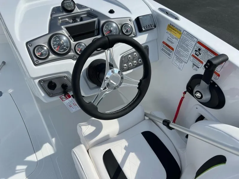 Slide: The Image of 2023 Tahoe 2150 boat dashboard with steering wheel, gauges, and control panel. - 5