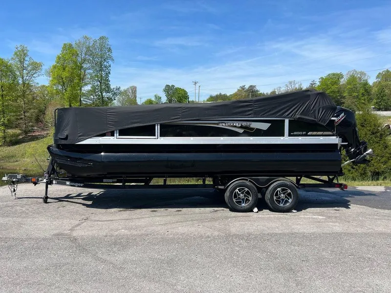 The Image of 2023 Ranger 200F boat on trailer with black cover, parked outdoors. - 1