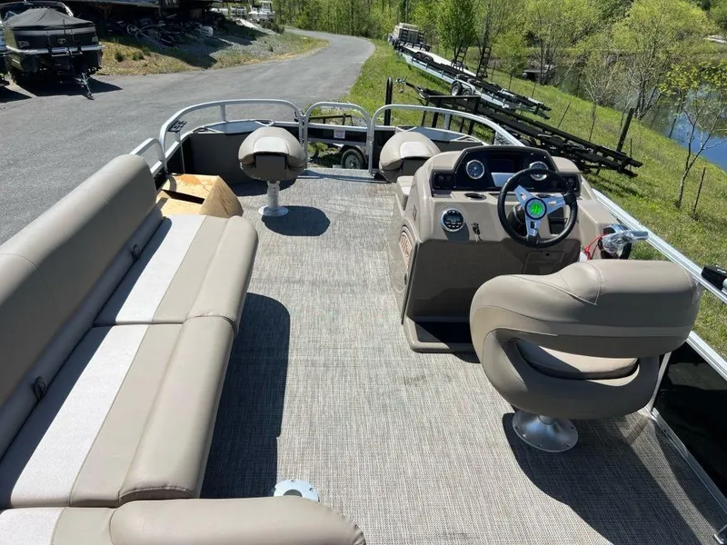Slide: The Image of 2023 Ranger 200F pontoon boat interior with beige seating and steering console. - 12