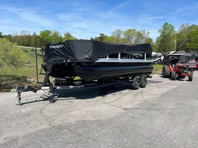 Slide: The Image of 2023 Ranger 200F boat on trailer, covered, parked outdoors near a tractor. - 4