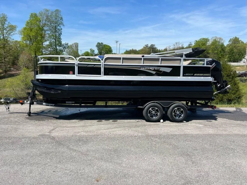 Slide: The Image of 2023 Ranger 200F pontoon boat on a trailer in a parking lot. - 5