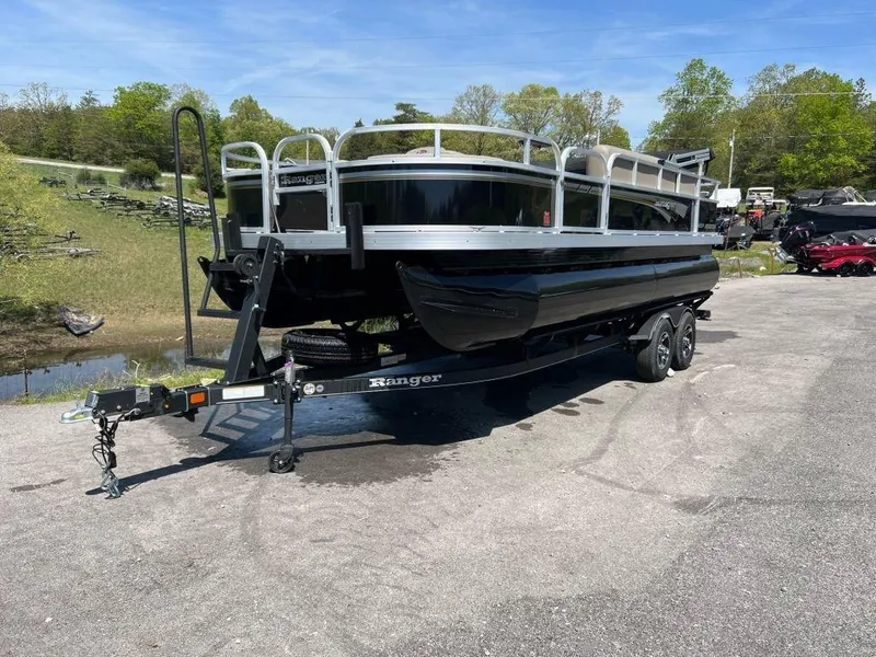 Slide: The Image of 2023 Ranger 200F pontoon boat on a trailer in a scenic outdoor setting. - 7