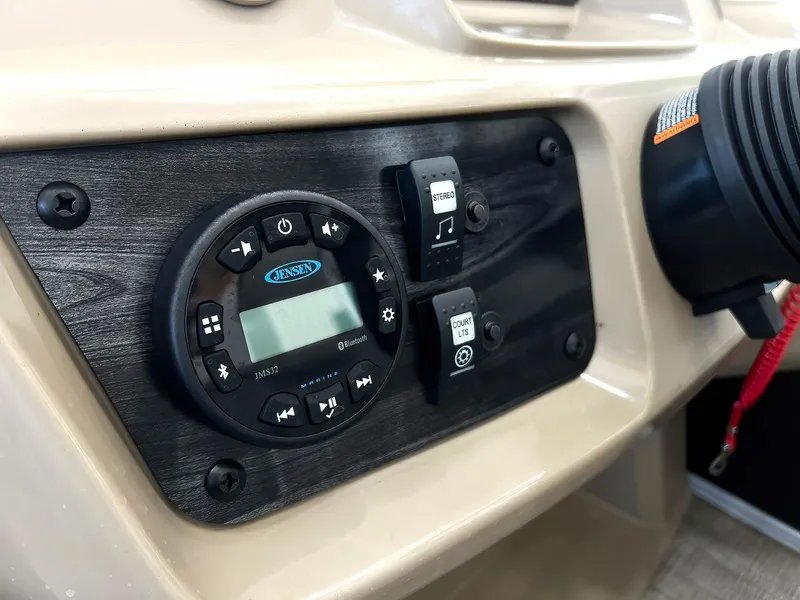 Slide: The Image of Control panel of 2023 Starcraft LX 22 R boat with audio system and switches. - 13