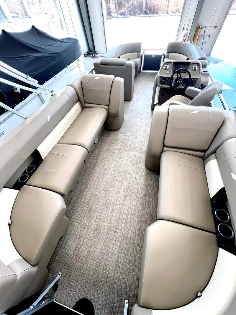 Slide: The Image of 2023 Starcraft LX 22 R pontoon boat interior with beige seating and modern dashboard. - 22