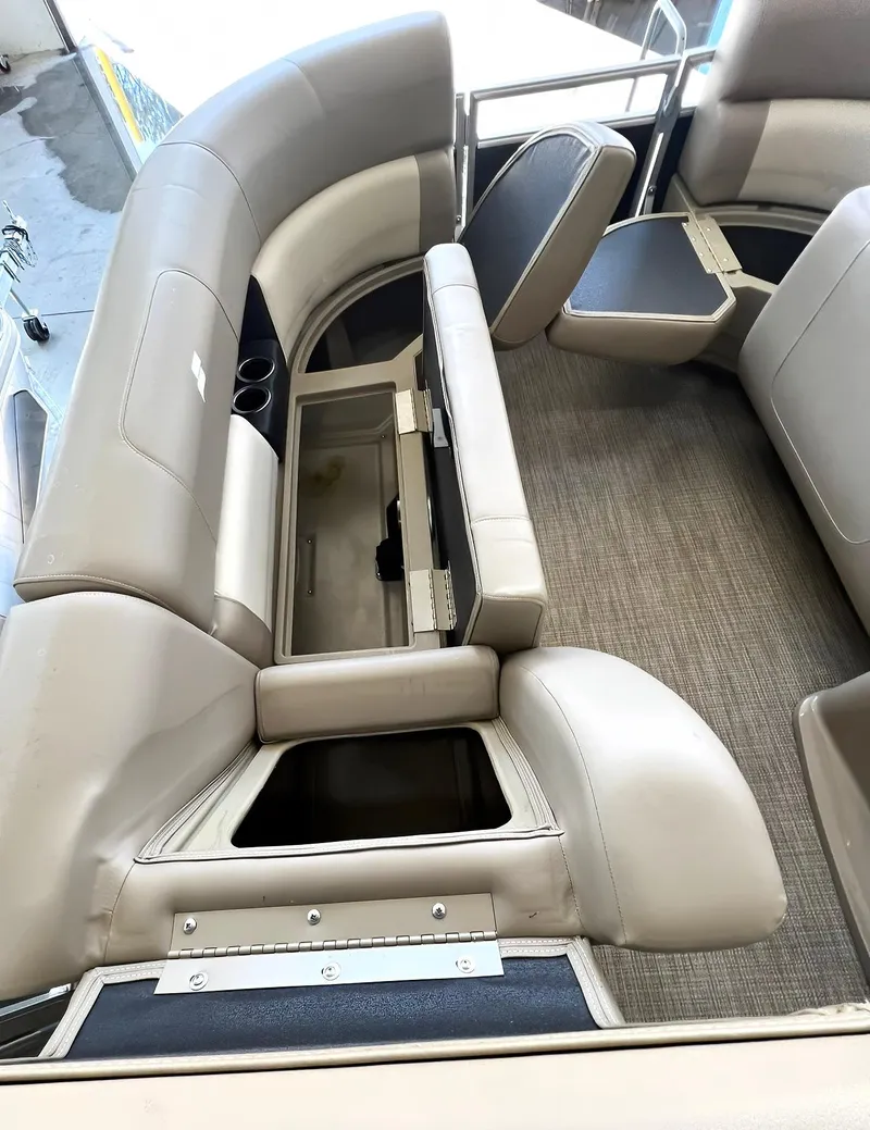Slide: The Image of 2023 Starcraft LX 22 R boat interior with beige seating and storage compartments. - 7