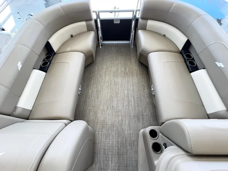 Slide: The Image of 2023 Starcraft LX 22 R boat interior with beige seating and cup holders. - 8