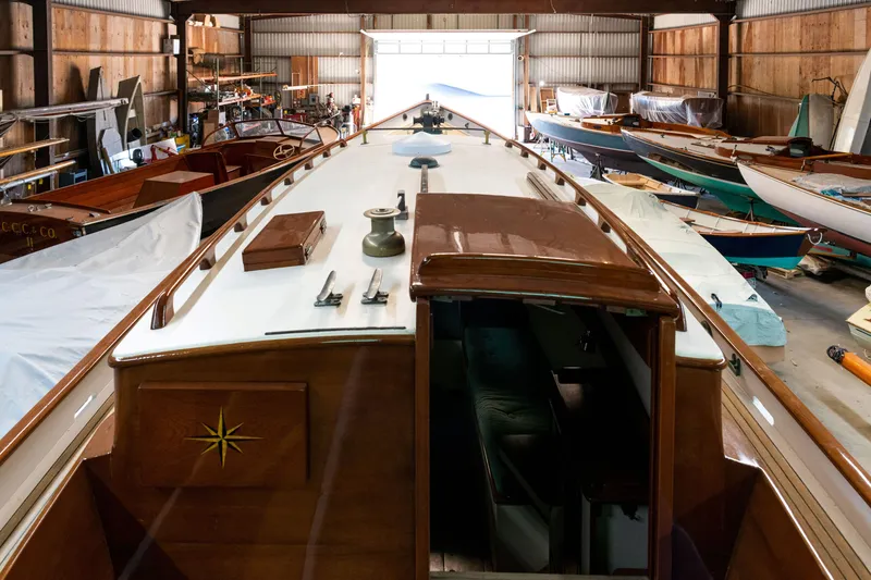 Slide: The Image of Custom 2008 Frank Paine Sloop in a boat workshop, surrounded by various vessels. - 14
