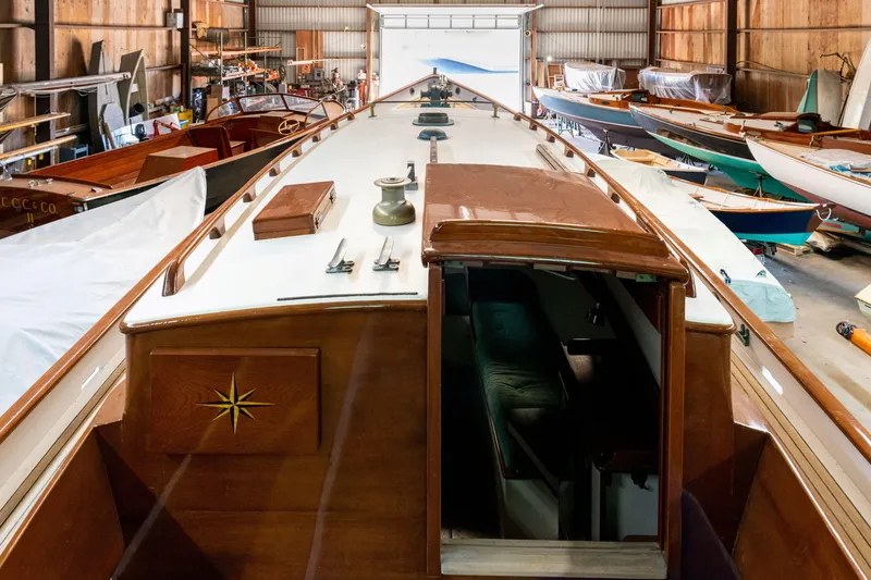 Slide: The Image of Custom 2008 Frank Paine Sloop in a boatyard, showcasing elegant wooden craftsmanship. - 17