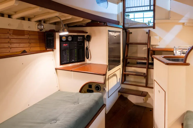 Slide: The Image of Interior of 2008 Custom Frank Paine Sloop, featuring cozy seating and navigation equipment. - 24