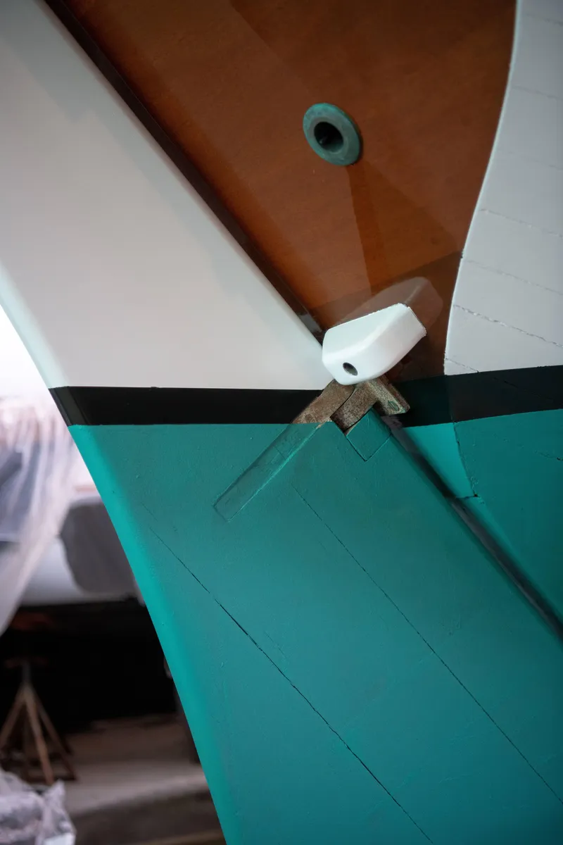 Slide: The Image of Close-up of a 2008 Custom Frank Paine Sloop's hull with teal and white paint. - 49