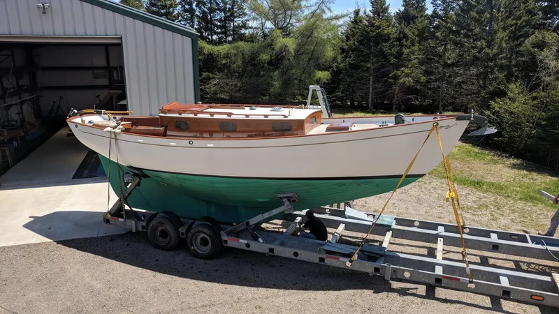 Slide: The Image of Custom 2008 Frank Paine Sloop on trailer, parked near a garage, surrounded by trees. - 5