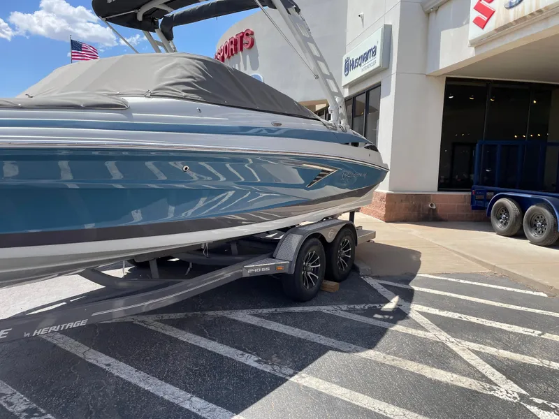 The Image of 2023 Crownline 240SS boat on a trailer outside a dealership. - 0