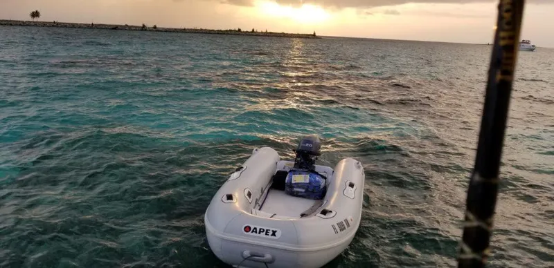 Slide: The Image of Apex A10 RIB 2022 inflatable boat on turquoise water at sunset. - 3