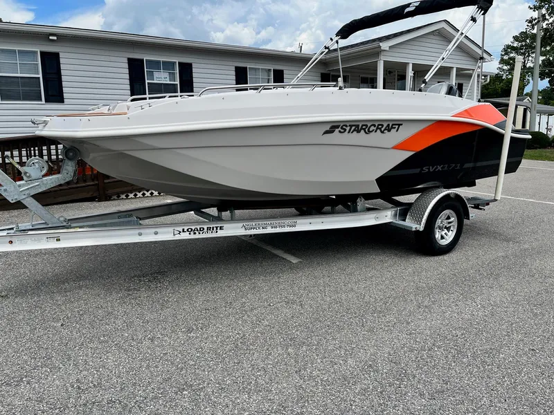 Slide: The Image of 2024 Starcraft SVX 171 boat on a Load Rite trailer in a residential area. - 0
