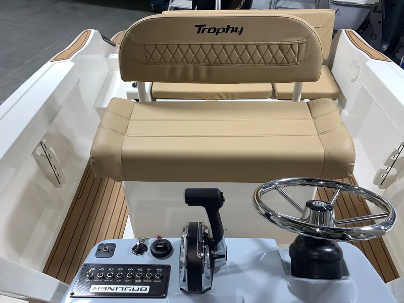Slide: The Image of 2024 Bayliner Trophy 22CC boat interior with beige seating and control console. - 12
