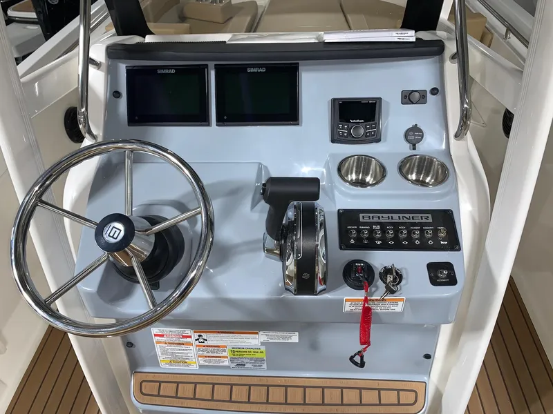 Slide: The Image of 2024 Bayliner Trophy 22CC boat console with steering wheel, controls, and dual displays. - 14