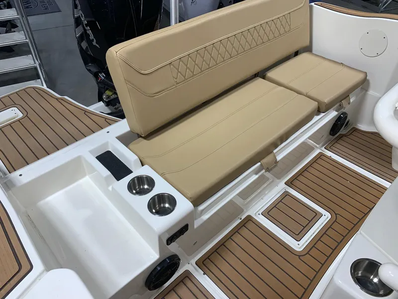 Slide: The Image of 2024 Bayliner Trophy 22CC boat with tan seating and wood-patterned deck. - 15