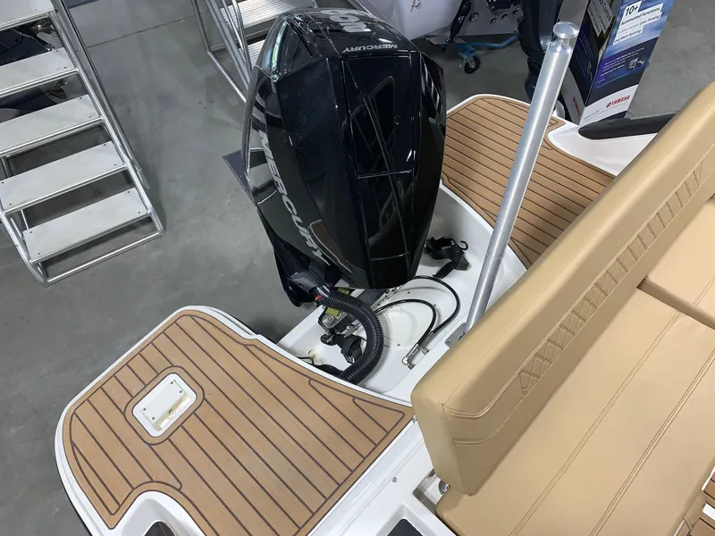 Slide: The Image of 2024 Bayliner Trophy 22CC boat with outboard motor and tan seating. - 4