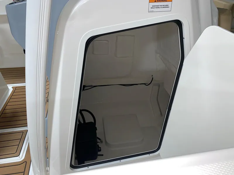 Slide: The Image of 2024 Bayliner Trophy 22CC storage compartment with teak flooring. - 5