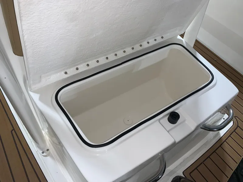 Slide: The Image of 2024 Bayliner Trophy 22CC storage compartment with open lid. - 10