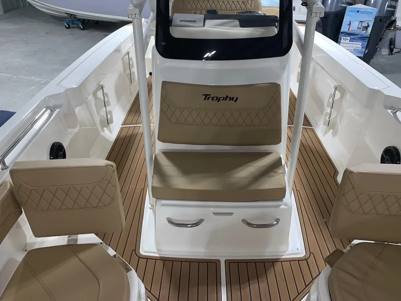 Slide: The Image of 2024 Bayliner Trophy 22CC boat interior with tan seating and wood flooring. - 6