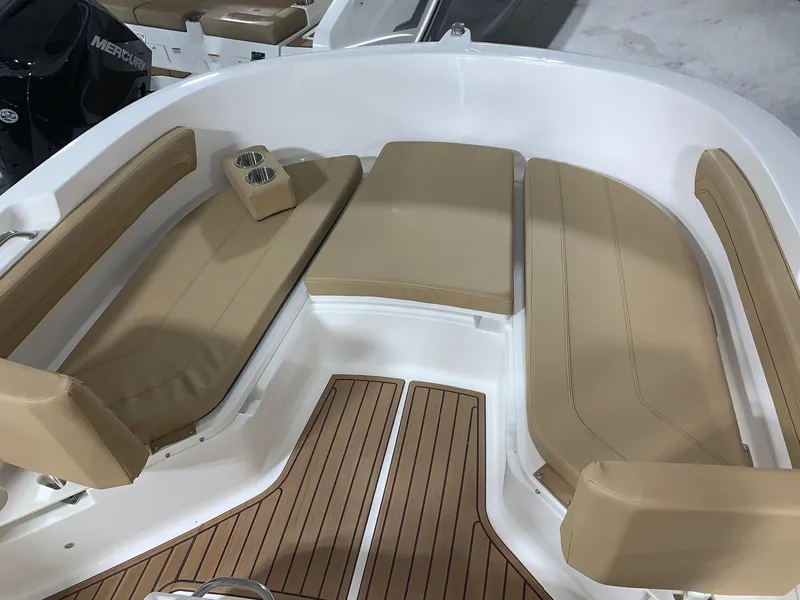 Slide: The Image of 2024 Bayliner Trophy 22CC boat with tan seating and wood-patterned flooring. - 7