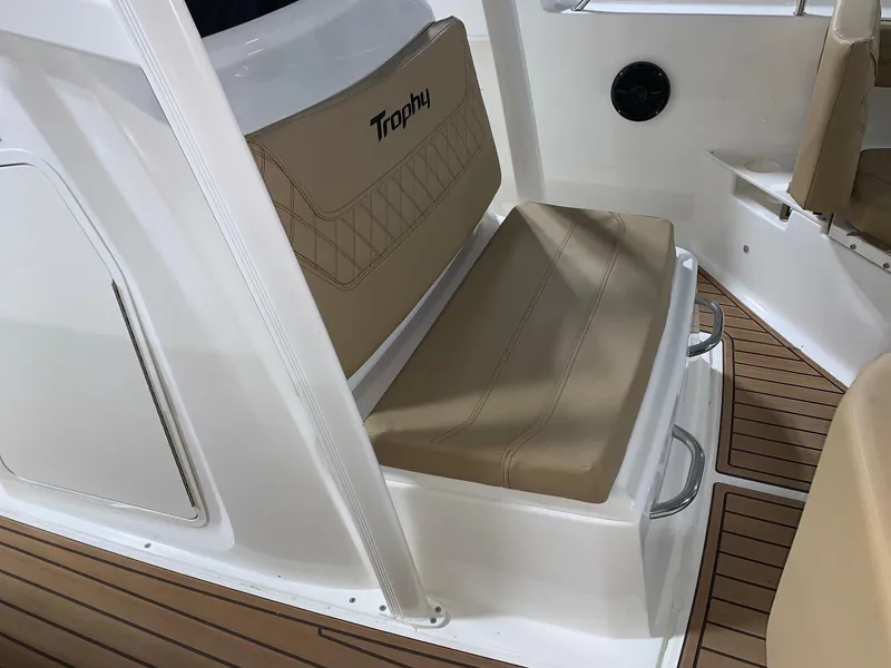 Slide: The Image of 2024 Bayliner Trophy 22CC boat interior with tan cushioned seating and teak flooring. - 9