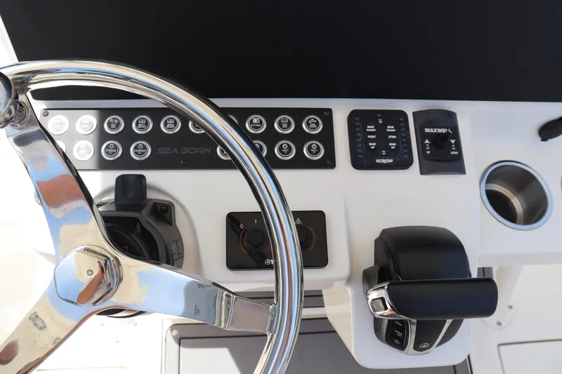Slide: The Image of 2023 Sea Born SX239 Offshore boat dashboard with steering wheel and control panel. - 22