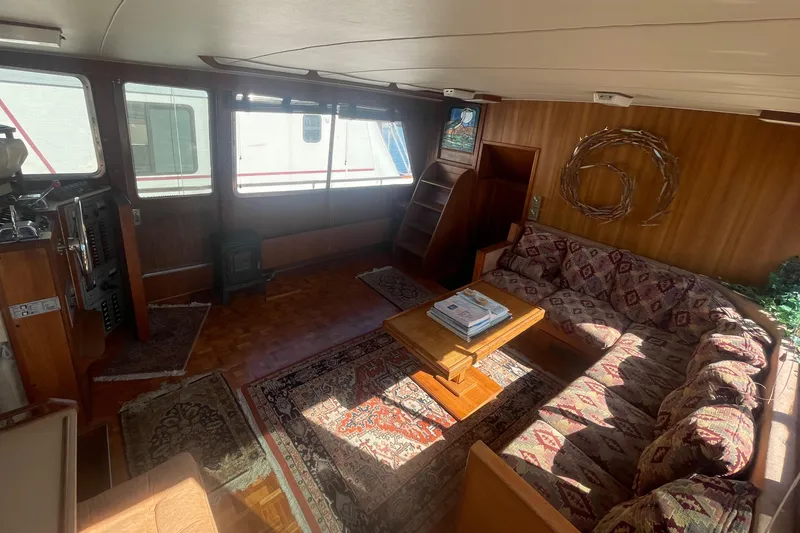 Slide: The Image of 1981 Tollycraft 48 Motor Yacht interior with cozy seating and wooden decor. - 13