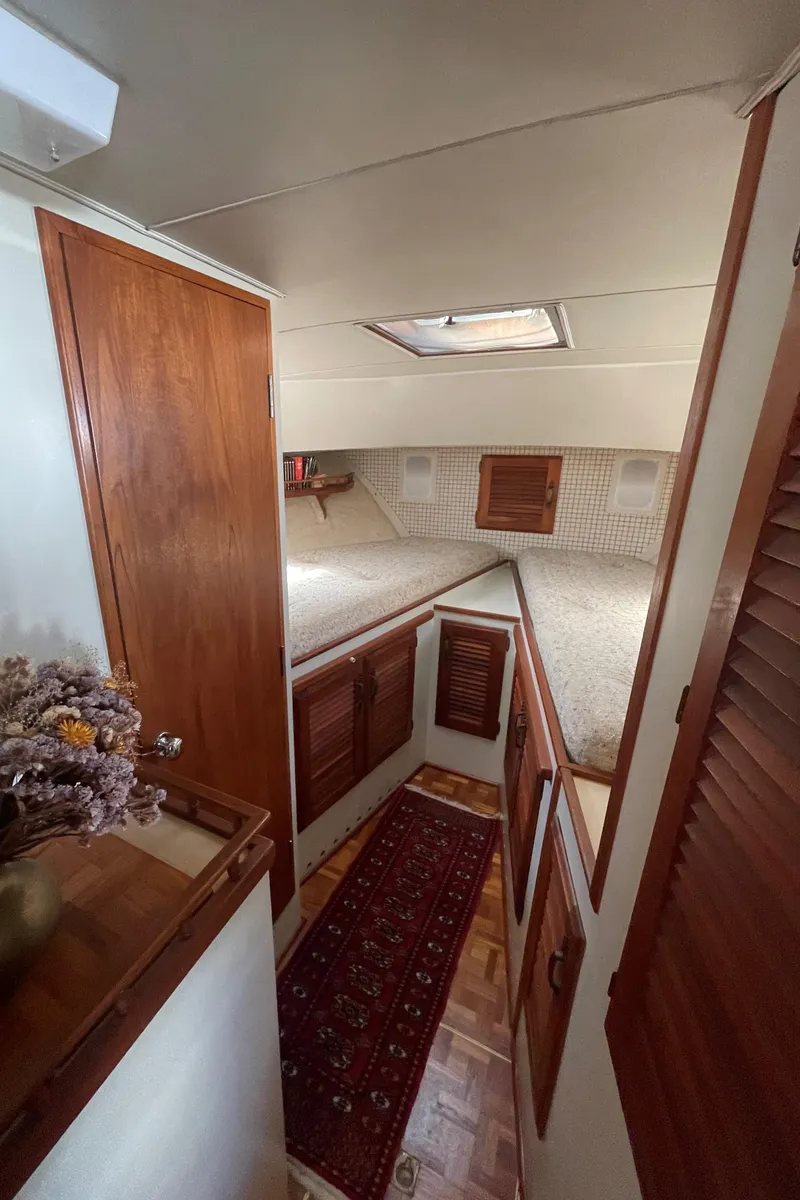 Slide: The Image of 1981 Tollycraft 48 Motor Yacht interior cabin with wood paneling and cozy bedding. - 22