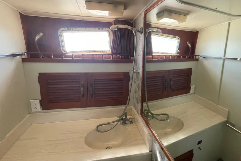 Slide: The Image of 1981 Tollycraft 48 Motor Yacht bathroom with dual sinks and mirrored cabinet. - 26